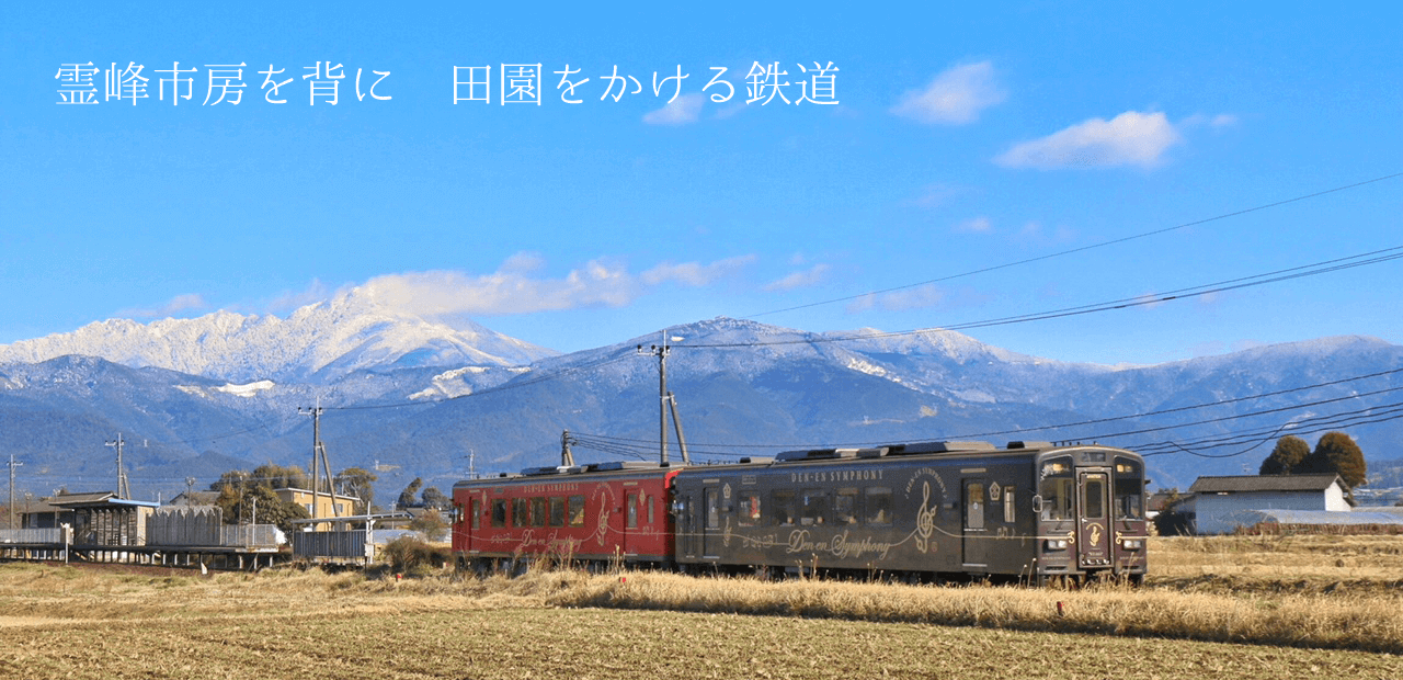 霊峰市房を背に田園をかける鉄道